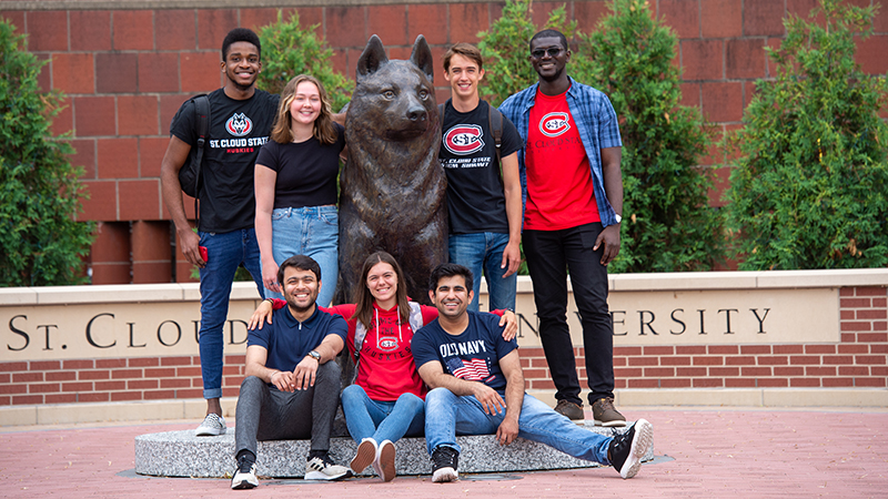 Group of students by husky statue