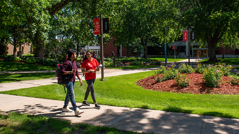 Students walking on campus sidewalk