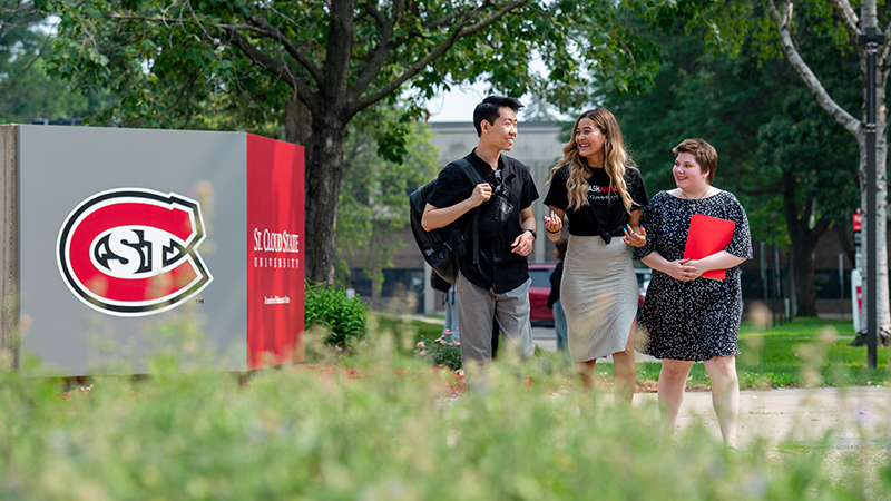 Three students walking outside Admissions