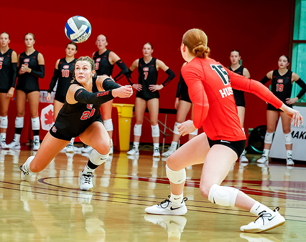 SCSU Women's Volleyball team - Player eyeing a ball for a dig.