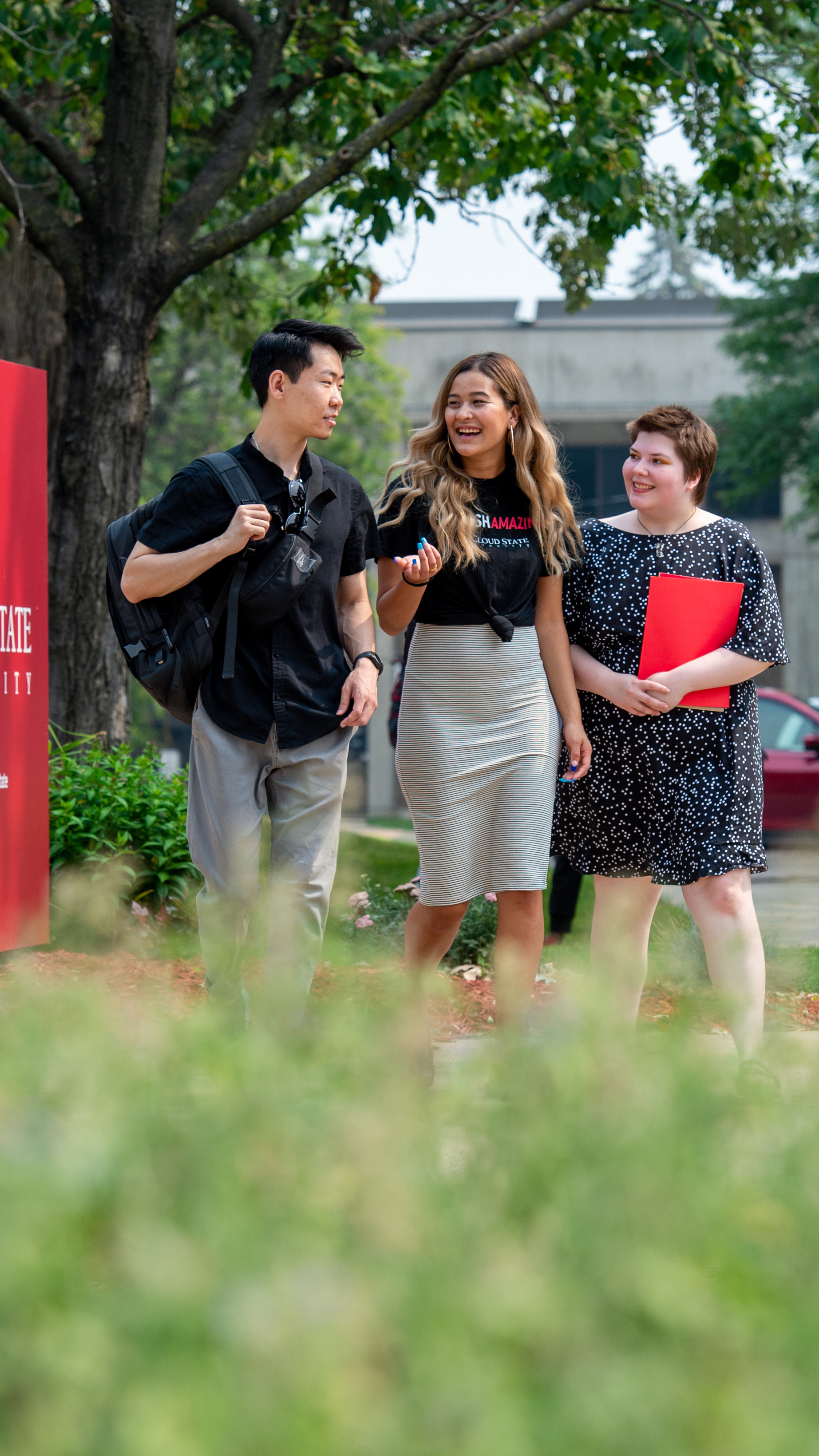 Students walking by campus sign