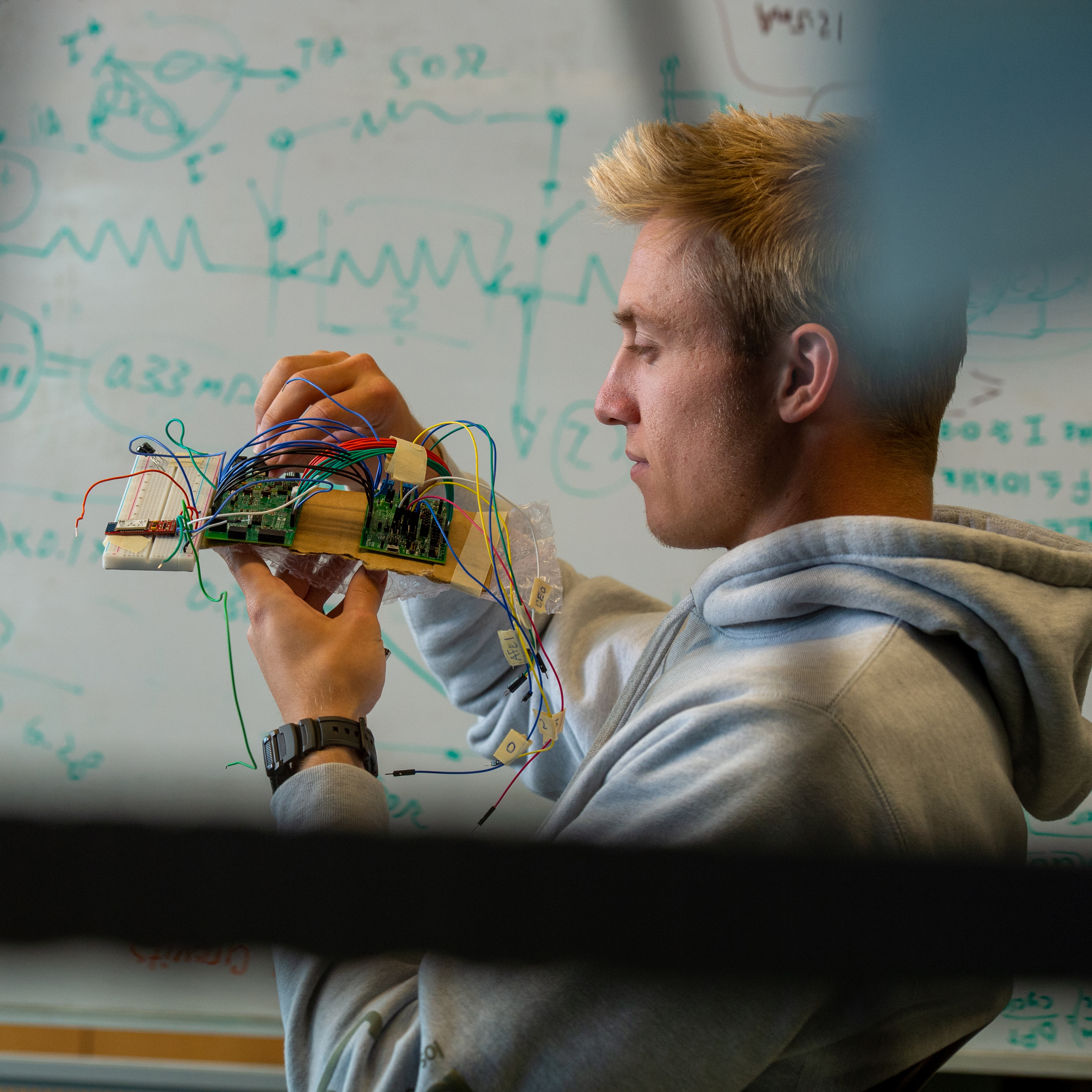 Student looking at computer board.