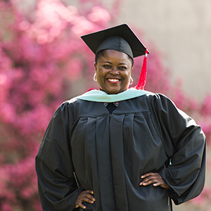 Master's graduate smiling at camera.