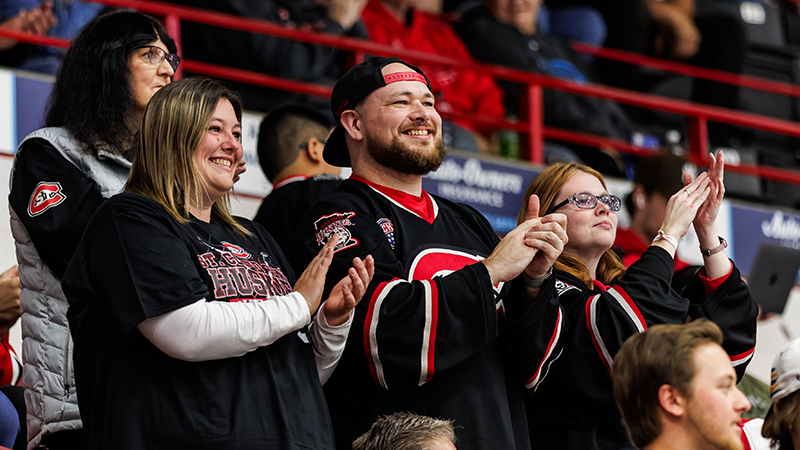 SCSU alumni clap for the Men's Hockey team at a game