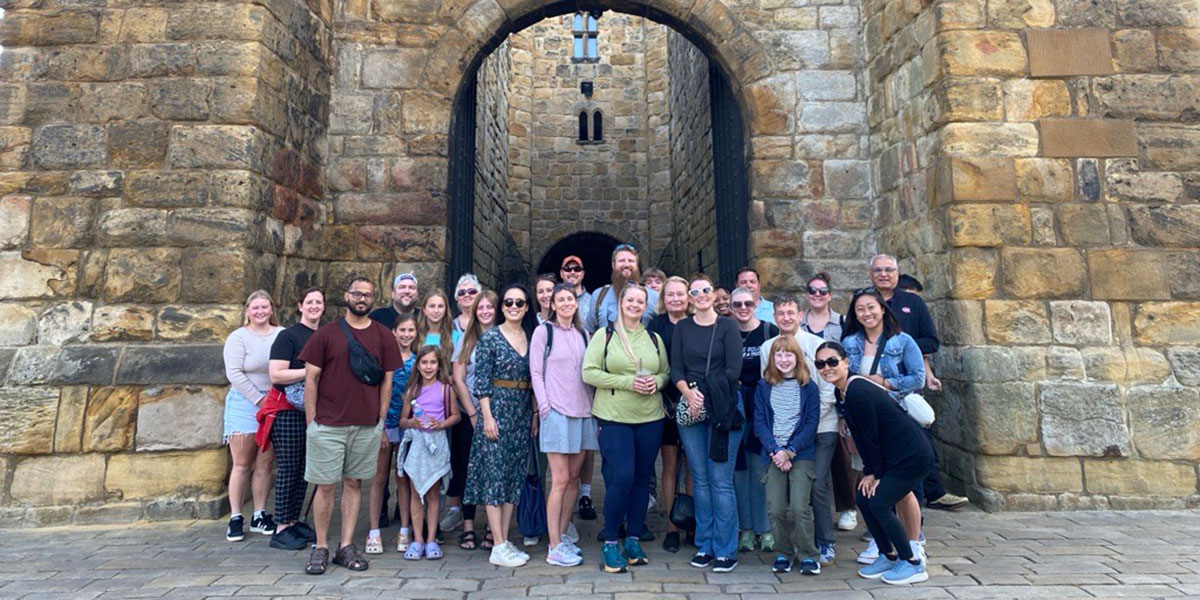 A group photo of workshop attendees in front of castle entrance