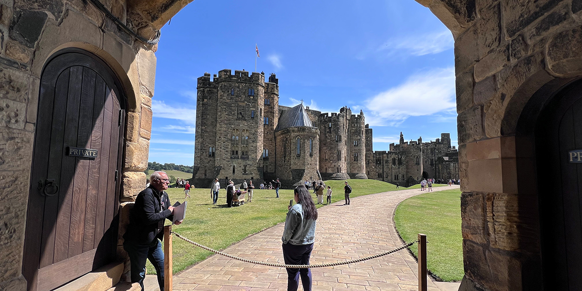 Two SCSU employees standing in the arched entryway of Alnwick Castle