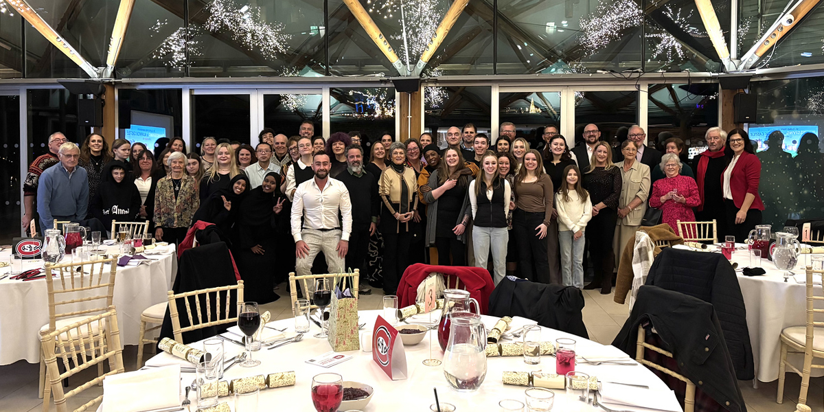 A group photo of people enjoying a Thanksgiving dinner in Alnwick, England