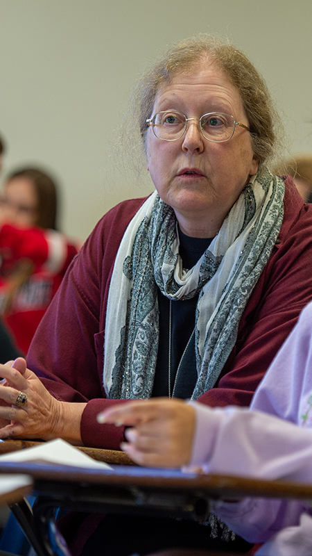 Faculty and students engaged in a discussion in an academic setting
