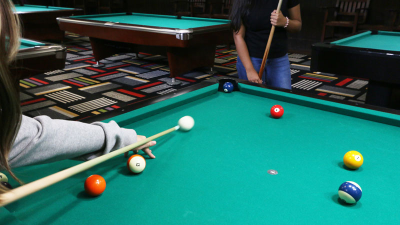 Two people play a game of pool at the Underground located in Atwood Memorial Center