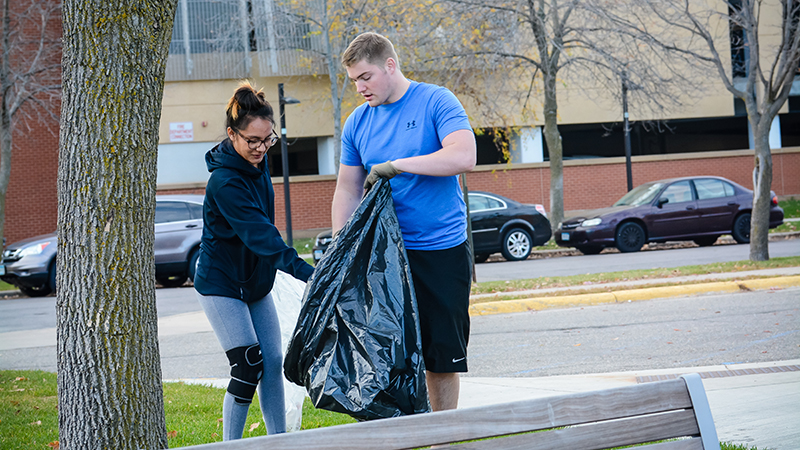 Two students picking up trash