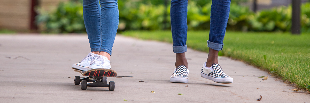 Feet on skate board and feet walking