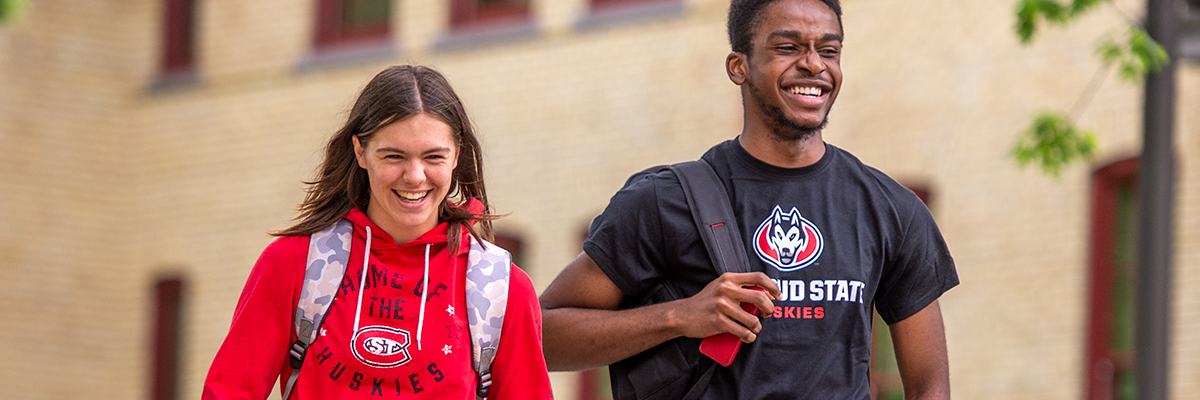 Students smiling on sidwalk