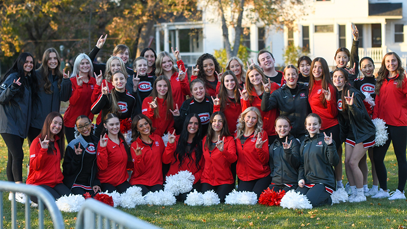 Cheer team doing sign of Husky