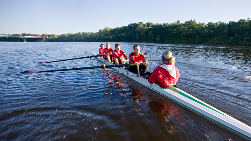 Crew team rowing on river