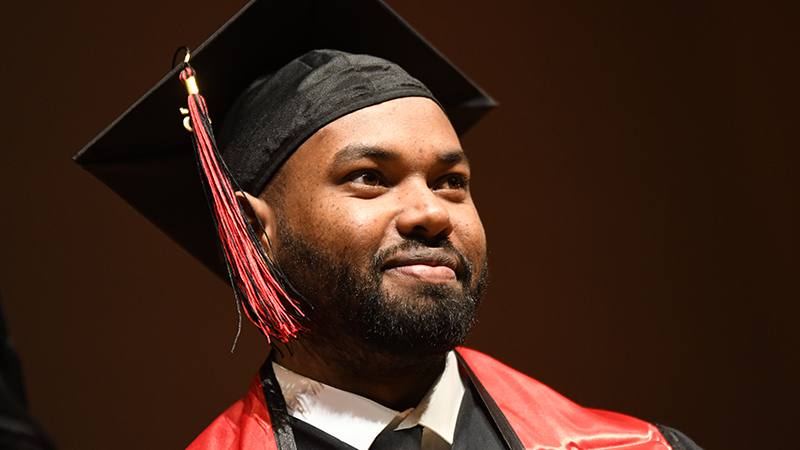 A proud graduate on stage at commencement