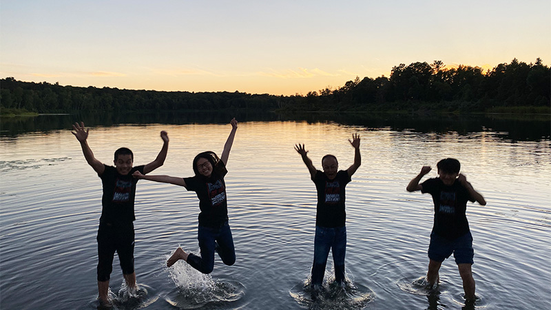 Chinese Visiting Scholar and Interns on a northern Minnesota lake, jumping cheerfully in the air during the sunset.  