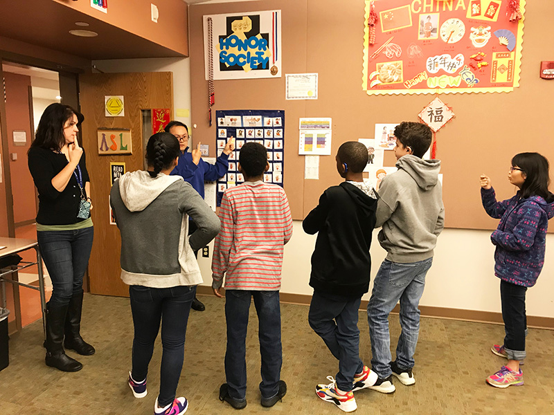 Chinese intern teacher teaching Chinese culture in a Deaf classroom full of Deaf students. 