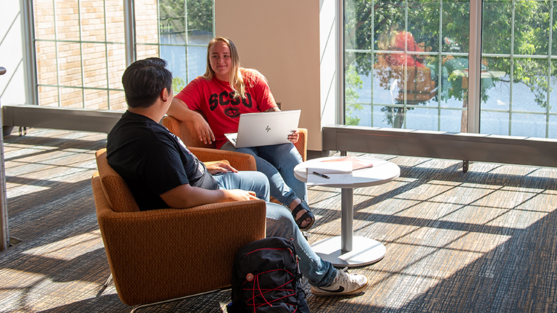 Two students talking in Eastman lounge