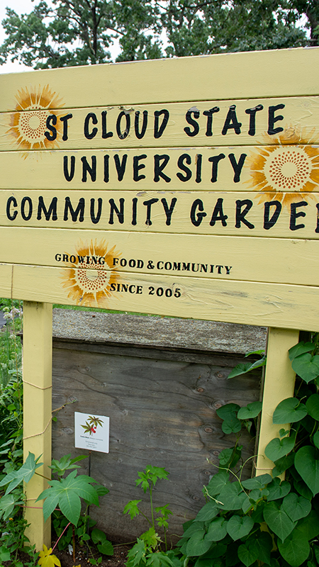 A bright yellow sign welcomes people into the garden.
