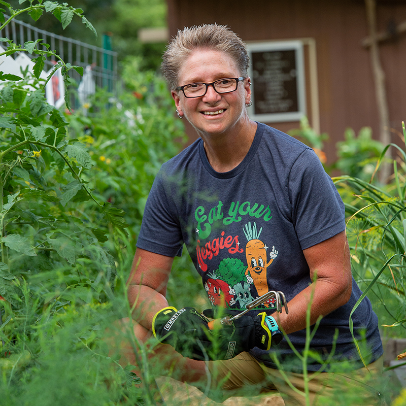 Tracy Ore kneeling in garden