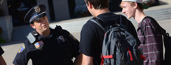 Officer talking with students on the St. Cloud State University Mall