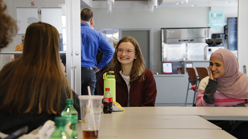 Student smiling at table