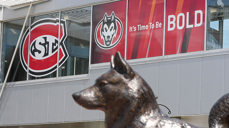 Bronze husky statue head with Atwood Memorial Center visible in the background