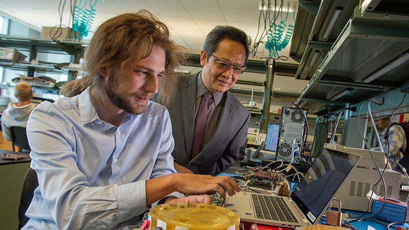 A SCSU engineering professor shows student something on laptop