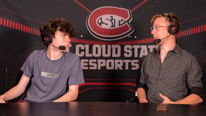 Two students looking at eachother wearing headsets