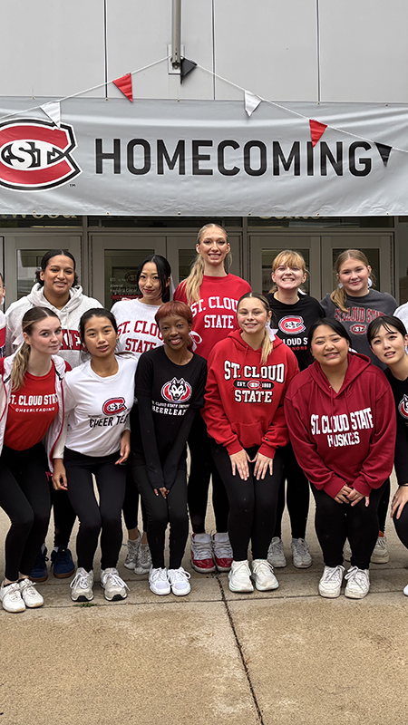  A group of SCSU students gather for a photo under a Homecoming banner outside Atwood Memorial Center