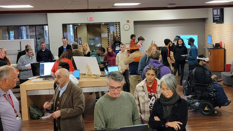 Many people talking and interacting with technology in a room
