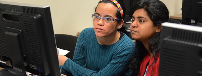 St. Cloud State students collaborate over work on a computer
