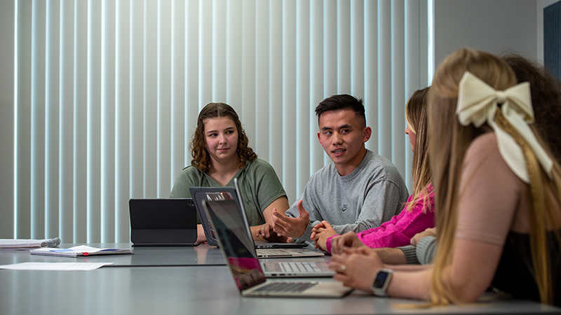 Small group of students work at a classroom table