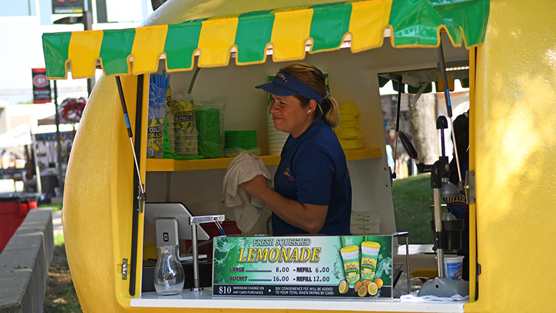 Person inside lemon-shaped lemonade stand