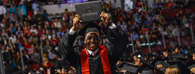 a student at graduation holding his diploma