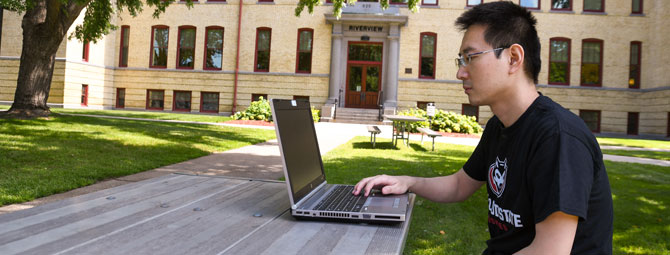 a male student working on a laptop computer