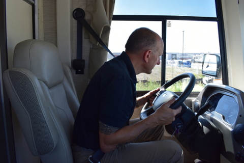 Man in Recreational Vehicle checking his mirror