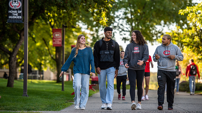 Four SCSU students walking on campus on a beautiful autumn day