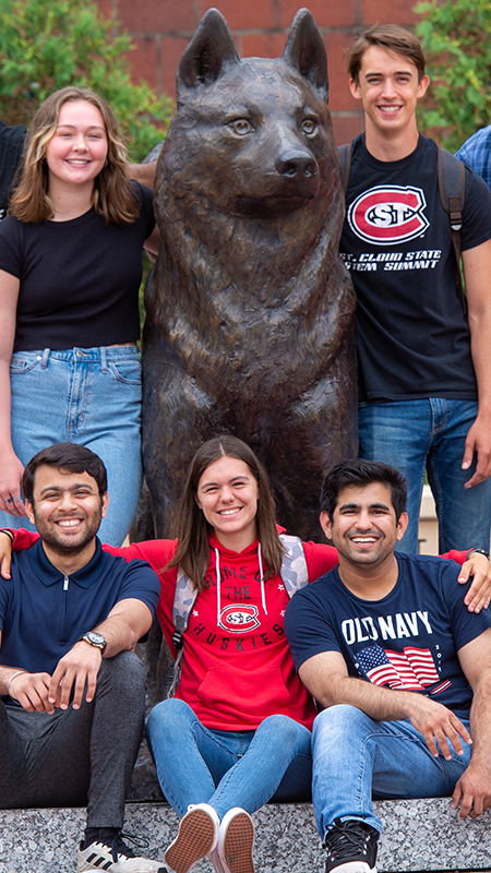 Students around husky statue