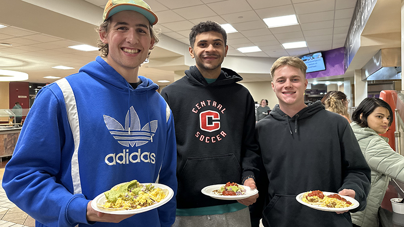 Three students with full plates at Garvey Commons