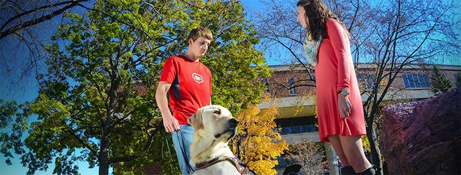 Two students with a service dog