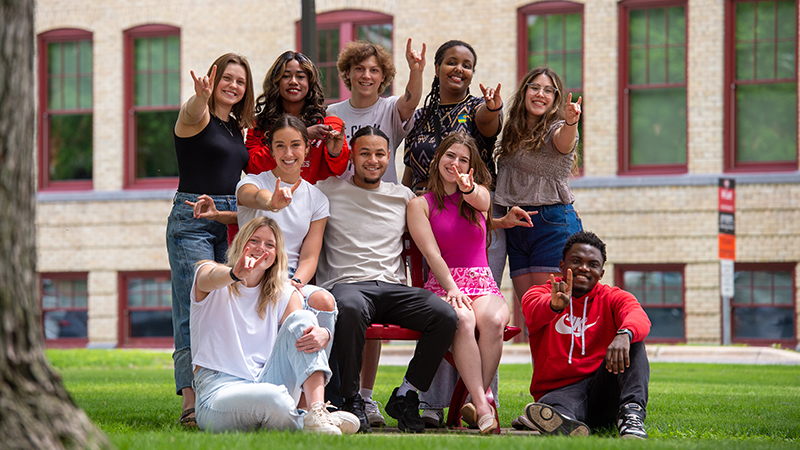 Group photo of SCSU students giving the "sign of the Husky"