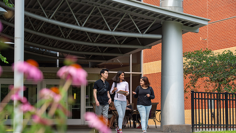 Three students exiting the Miller Center