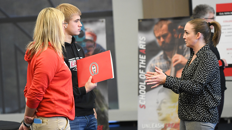 Parent, prospective student talking to staff member