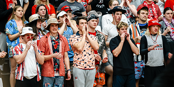 A group of SCSU students (the Dog Pound) cheer at a volleyball game