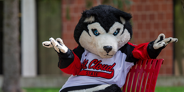 Blizzard mascot seated on an outdoor bench with arms shrugged