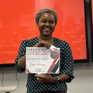 An expo participant smiles with honorable mention certificate in hand