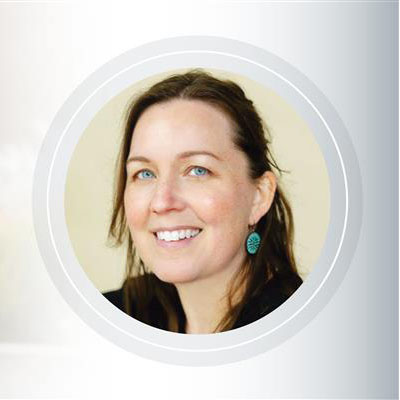 A headshot of a woman with brown hair and blue eyes smiling