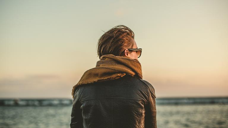 a person on a beach looking towards the ocean